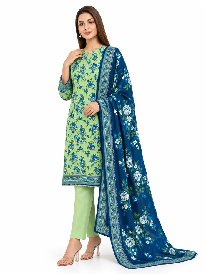 A woman modeling a traditional Indian salwar kameez suit set. The set features a light green kurta with blue floral prints, light green trousers, and a deep blue dupatta with white floral patterns and a gold border.