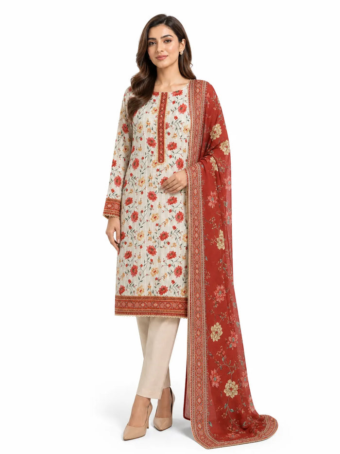 A woman modeling a traditional Indian salwar kameez suit set. The set features an off-white kurta with red and orange floral prints and gold borders, paired with beige trousers and a rust-red dupatta with gold floral motifs and borders.
